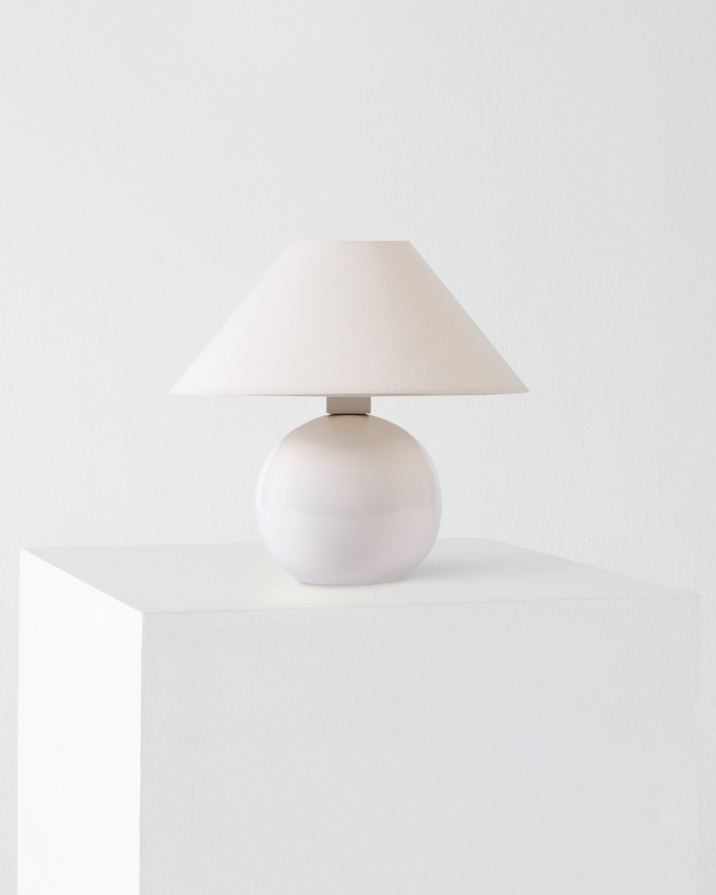 Table lamp with a white shade on a white surface and background
