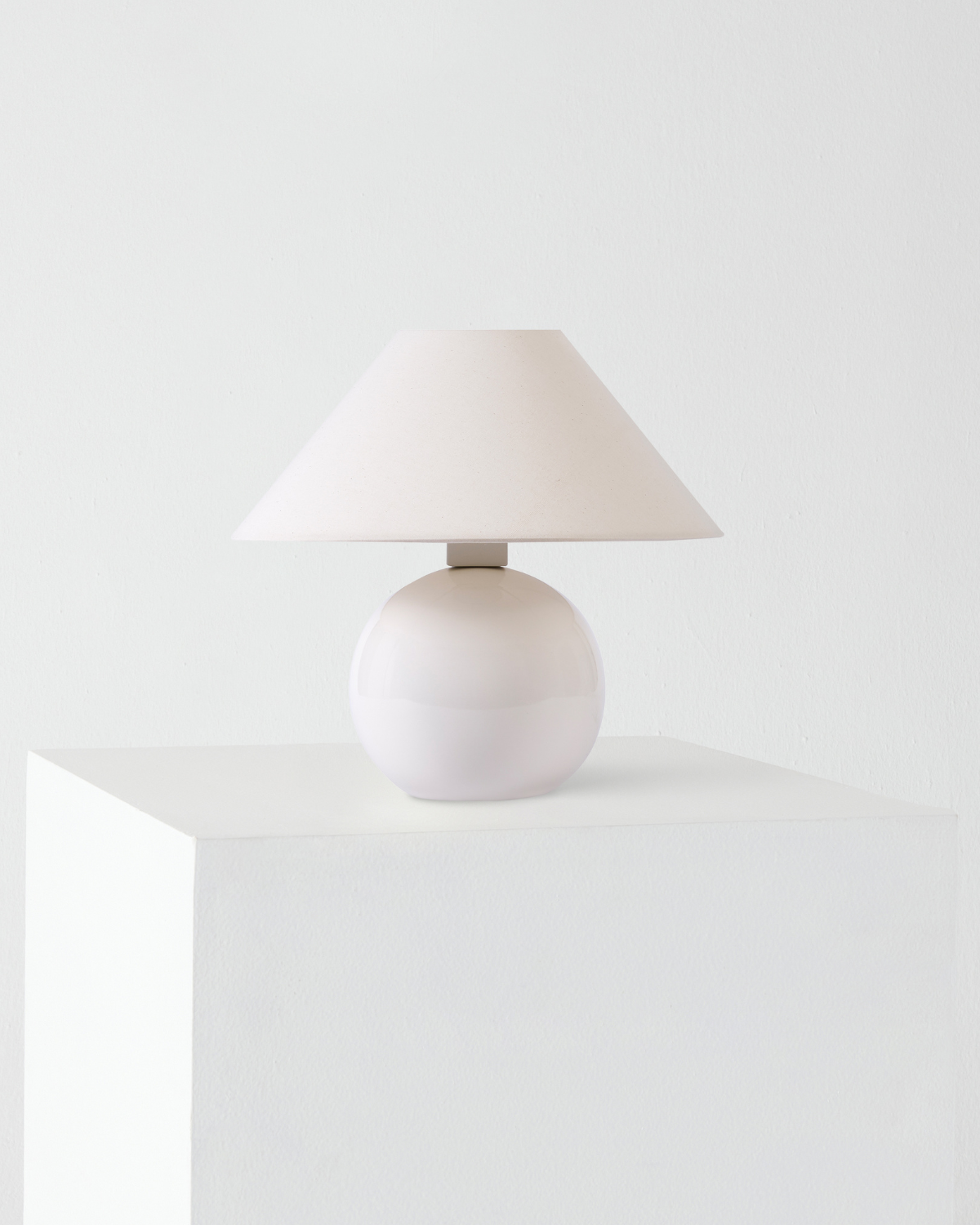 Table lamp with a white shade on a white surface and background