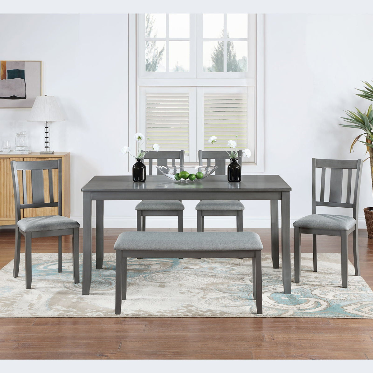 Gray dining set with table and chairs in a room with a window and rug.