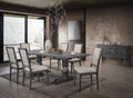 A rustic gray wooden dining table with six matching gray upholstered chairs, styled in a modern, warm-toned dining room with textured walls, a chandelier, and a sideboard.