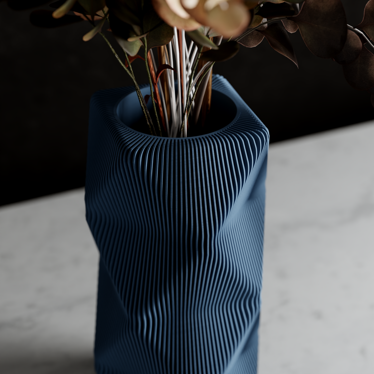 Blue textured vase with dried flowers on a light surface